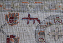 A close-up of a handwoven Afghan Chobi rug featuring traditional floral motifs in earthy tones.