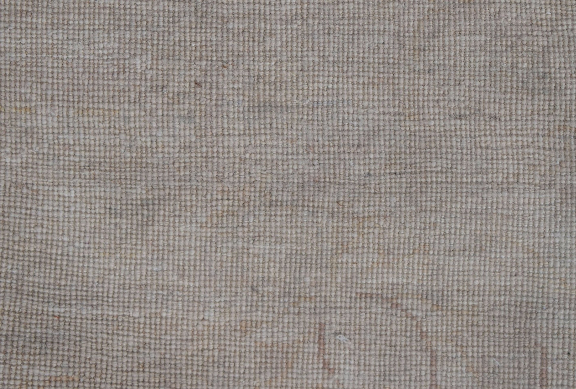 A close-up view of a handwoven Afghan Chobi rug featuring a textured, neutral-toned wool weave.