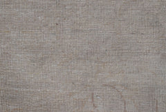 A close-up view of a handwoven Afghan Chobi rug featuring a textured, neutral-toned wool weave.