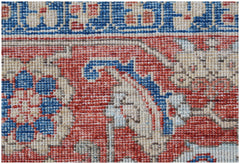A close-up of a handwoven Afghan Chobi rug featuring intricate floral patterns in red and blue.