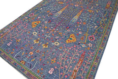 A handmade Afghan Chobi rug featuring a blue field with intricate floral and botanical patterns.