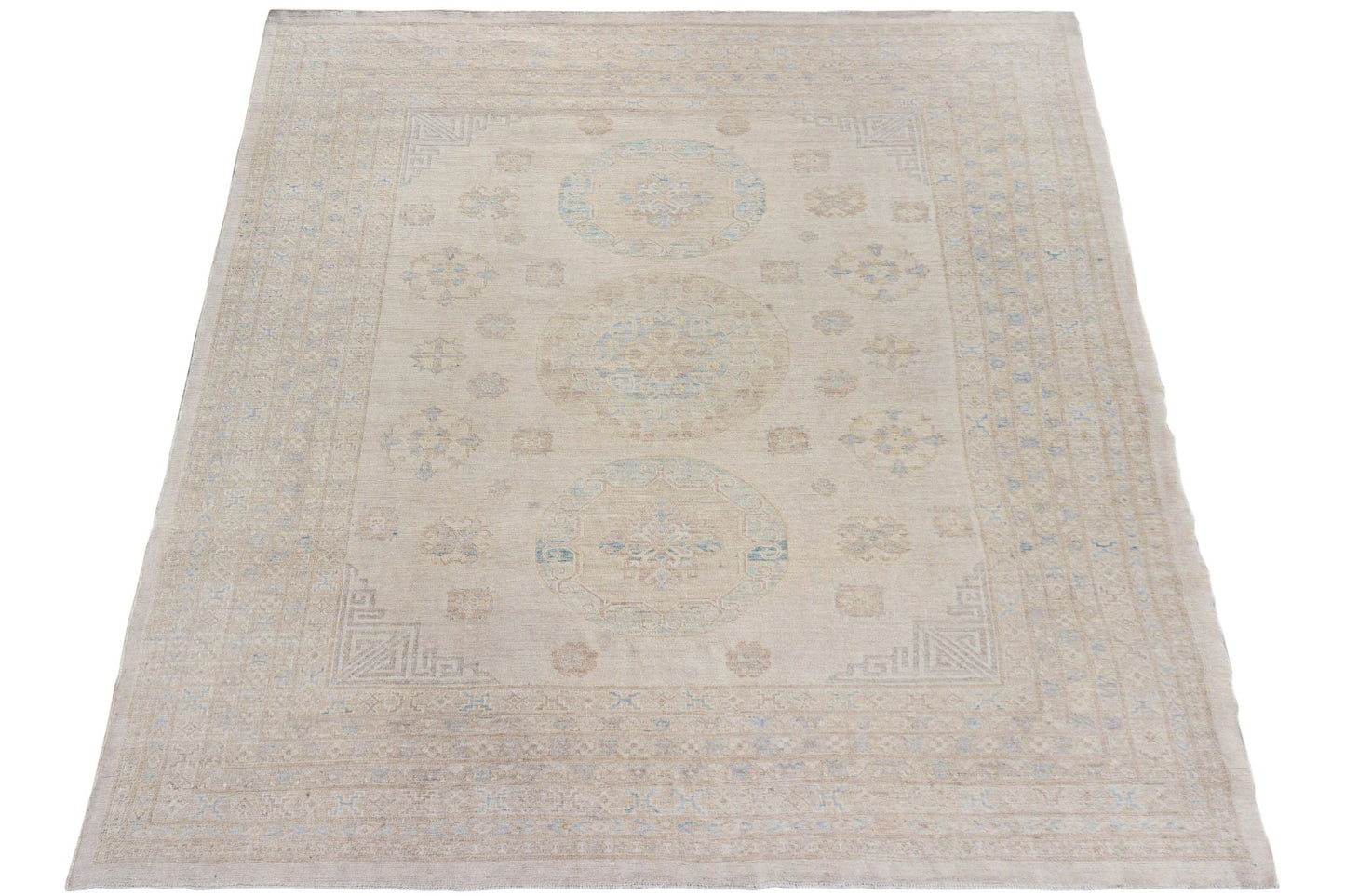 A handmade Afghan Chobi rug featuring a neutral beige palette with subtle blue medallion patterns.