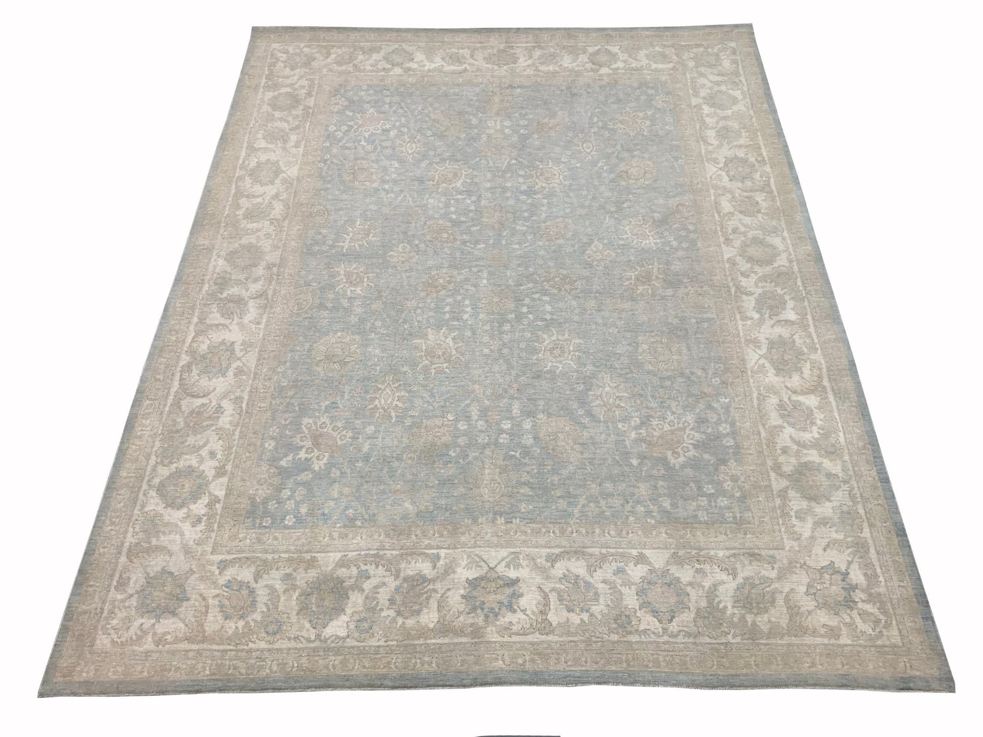 A handmade Afghan Chobi rug featuring a traditional floral pattern in soft blue and beige tones.