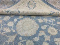 A handmade Afghan Chobi rug featuring a floral pattern in shades of blue and cream.