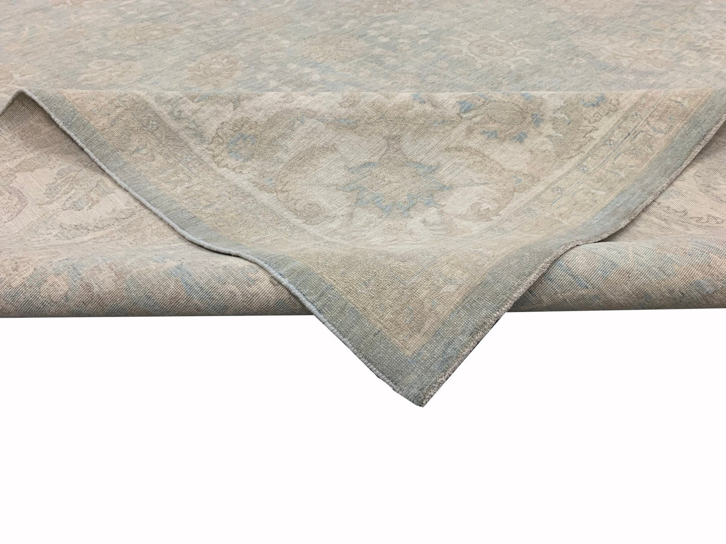 A handmade Afghan Chobi rug featuring a traditional floral pattern in soft beige and blue tones.