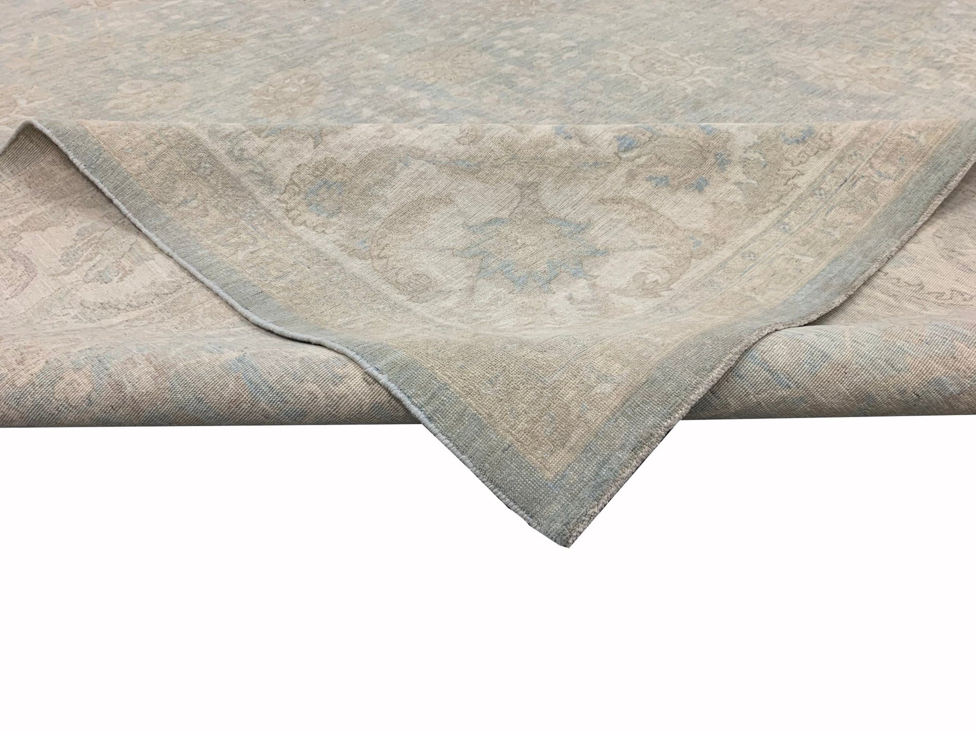 A handmade Afghan Chobi rug featuring a traditional floral pattern in soft beige and blue tones.