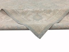 A handmade Afghan Chobi rug featuring a traditional floral pattern in soft beige and blue tones.