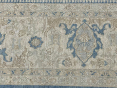 A handmade Afghan Chobi rug featuring a traditional blue and beige floral medallion pattern.