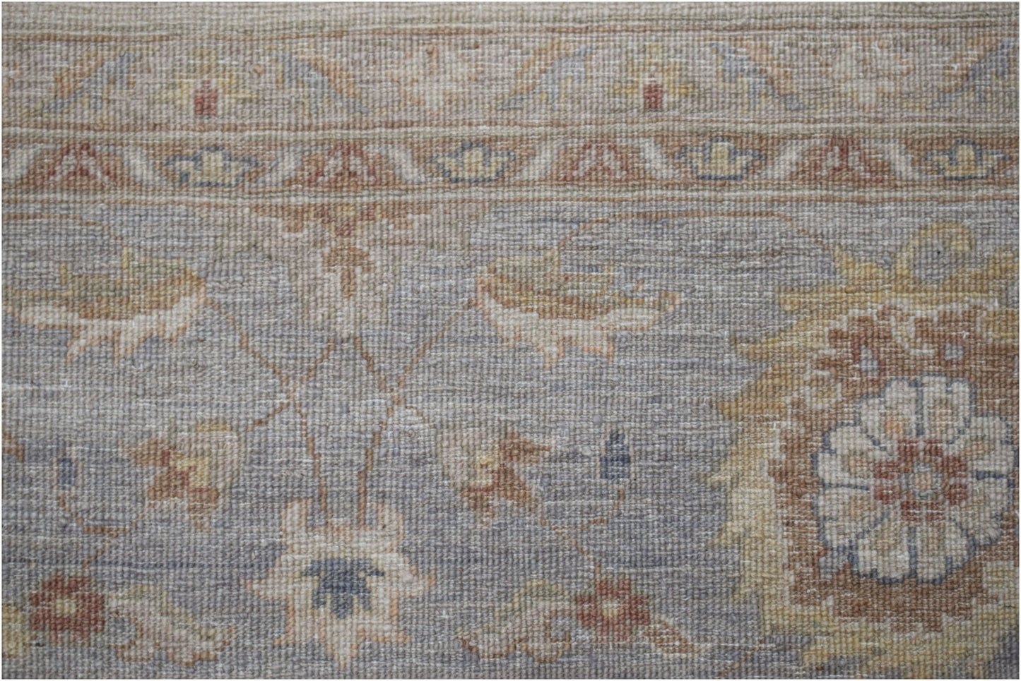 A handwoven Afghan Chobi rug featuring a traditional floral pattern in muted earth tones.