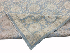 A handmade Afghan Chobi rug featuring a traditional floral pattern in soft blue and beige tones.