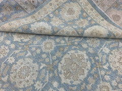 A handmade Afghan Chobi rug featuring a traditional floral pattern in shades of blue and beige.