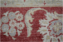 A close-up of an Afghan Chobi rug featuring intricate floral patterns in red, cream, and grey.