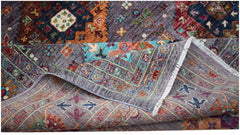 A handwoven Afghan Chobi rug featuring intricate geometric patterns in vibrant, earthy tones.
