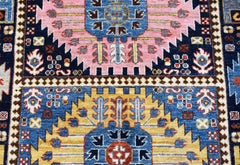 A handwoven Afghan Chobi rug featuring geometric patterns in blue, pink, and yellow wool.