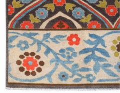 A handwoven Afghan Chobi rug featuring a floral pattern in blue, red, and green on a cream base.