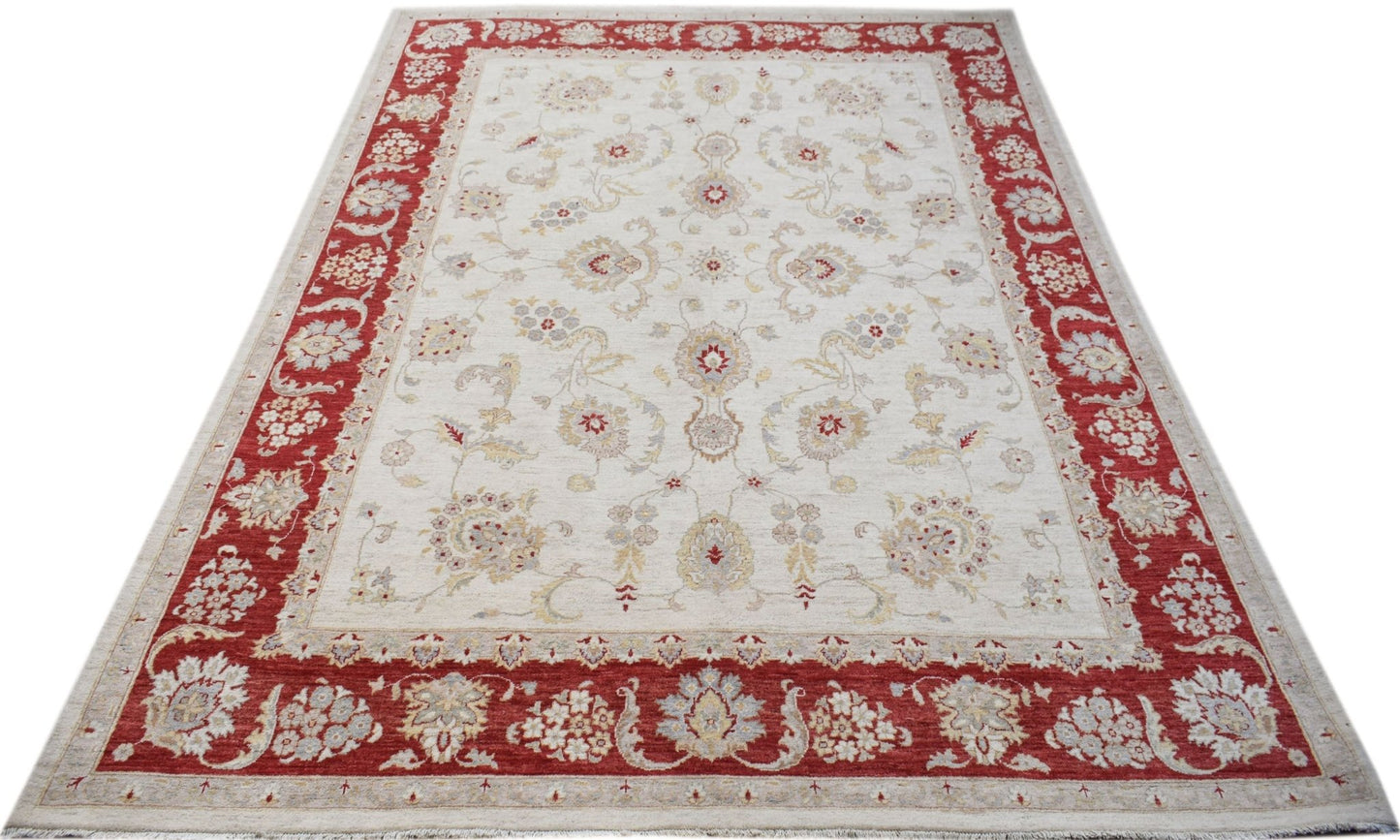 An Afghan Chobi rug featuring a cream field with floral motifs and a wide red border.