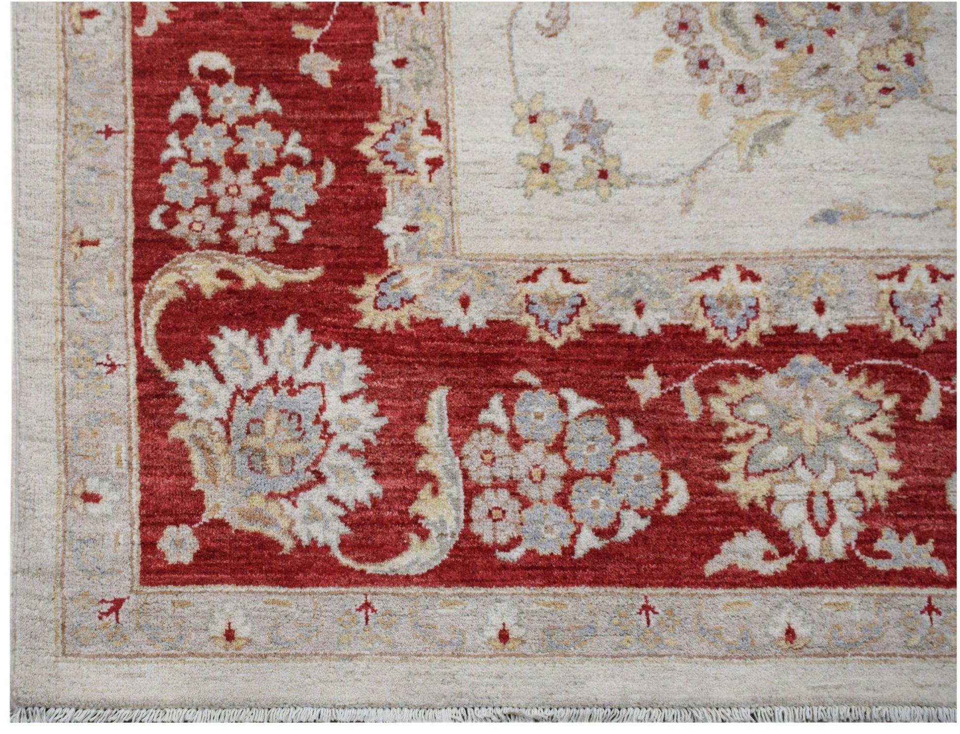 A handwoven Afghan Chobi rug featuring a red border with floral patterns and a cream center.