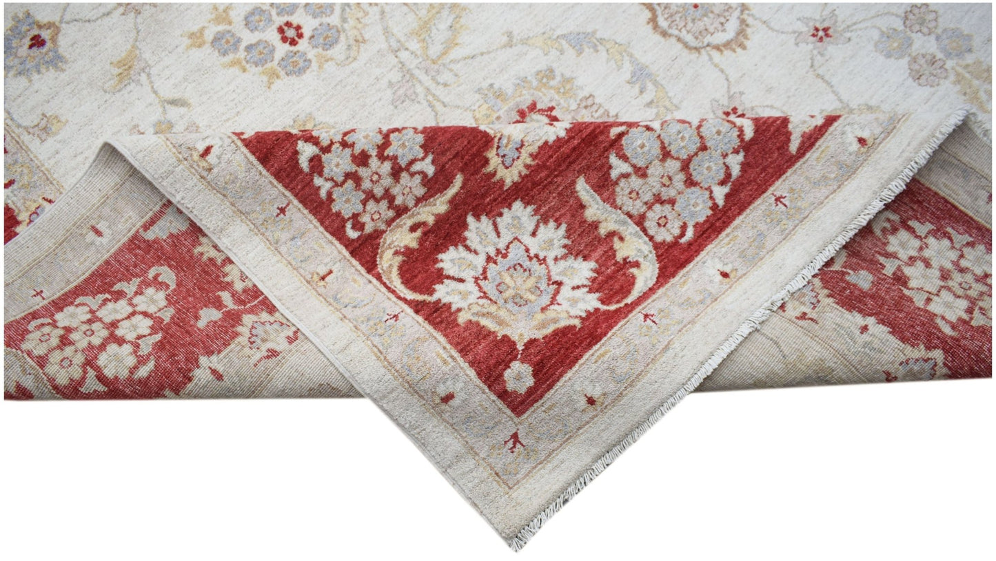 A handwoven Afghan Chobi rug featuring a floral pattern in red and cream tones.