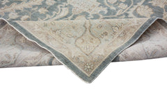 An Afghan Chobi rug with a traditional floral pattern in muted blue and beige tones.