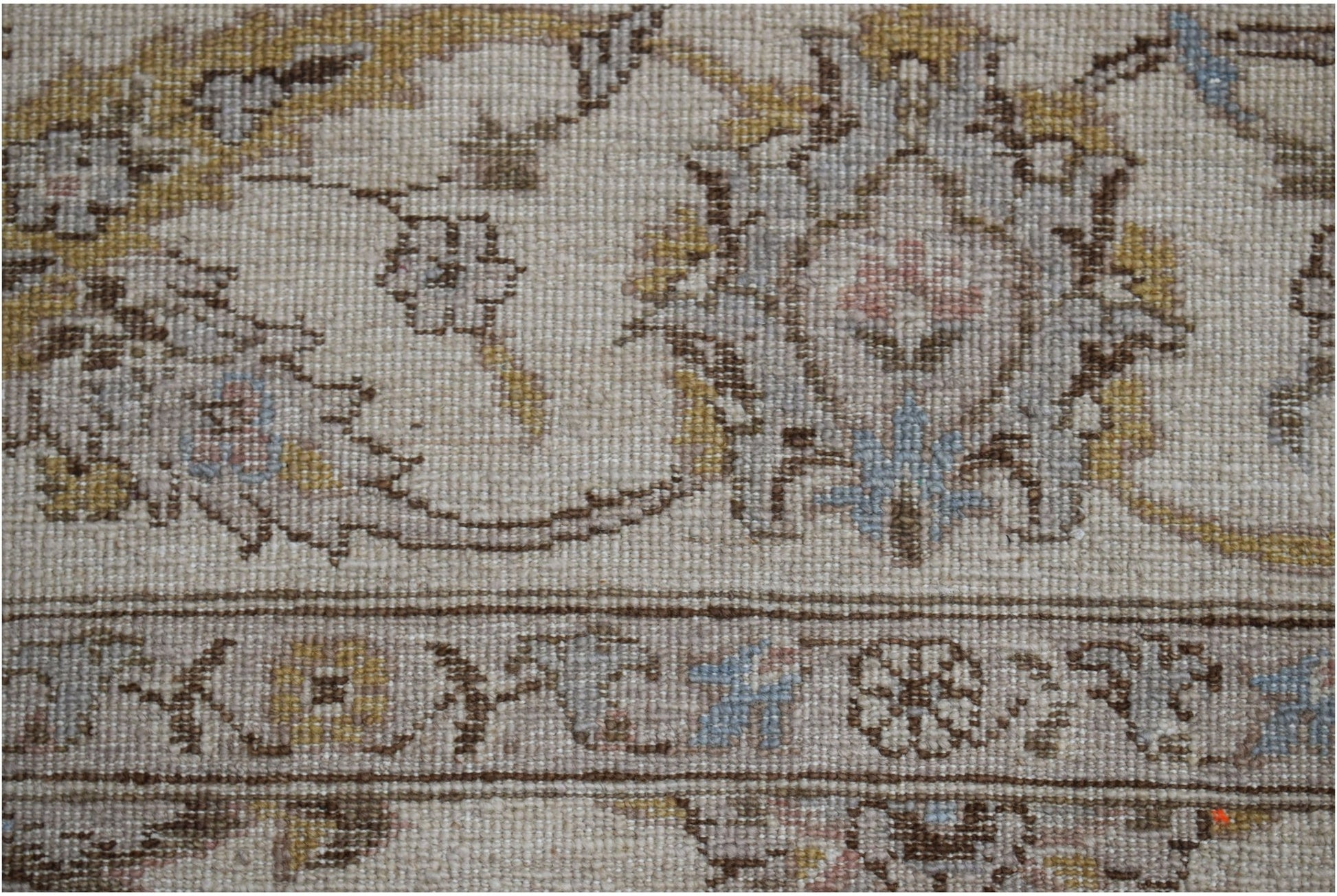 A close-up of a handwoven Afghan Chobi rug featuring traditional floral patterns in muted tones.