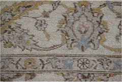 A close-up of a handwoven Afghan Chobi rug featuring traditional floral patterns in muted tones.