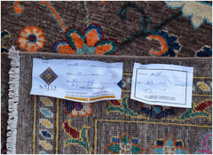 An Afghan Chobi rug with a brown field and colorful floral patterns, shown with product tags.