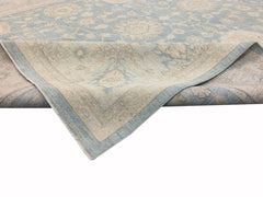 An Afghan Chobi rug featuring a light blue and beige floral pattern with a folded corner.