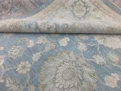 A handmade Afghan Chobi rug featuring a traditional floral pattern in shades of blue and beige.