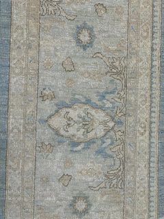 Handmade Afghan Chobi rug featuring a traditional floral pattern in soft blue and beige tones.