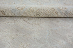 A close-up of a handmade Afghan Chobi rug in neutral tones with a folded corner.
