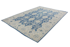 An Afghan Chobi rug featuring a traditional blue and beige floral pattern on a wool pile.