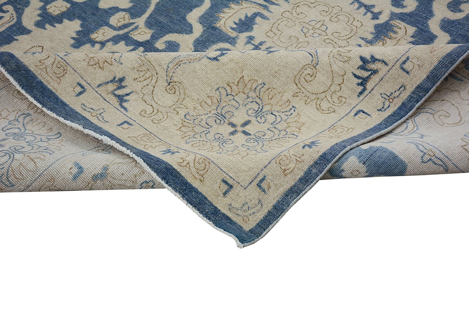 A handmade Afghan Chobi rug featuring a traditional blue and beige floral pattern.