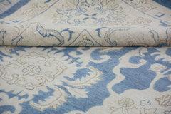 A handmade Afghan Chobi rug featuring a traditional blue and cream floral pattern.