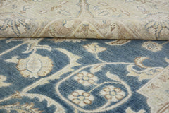 A handmade Afghan Chobi rug featuring a blue field with floral patterns and a folded corner.