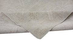 A handmade Afghan Chobi rug in neutral beige tones with a traditional floral pattern.