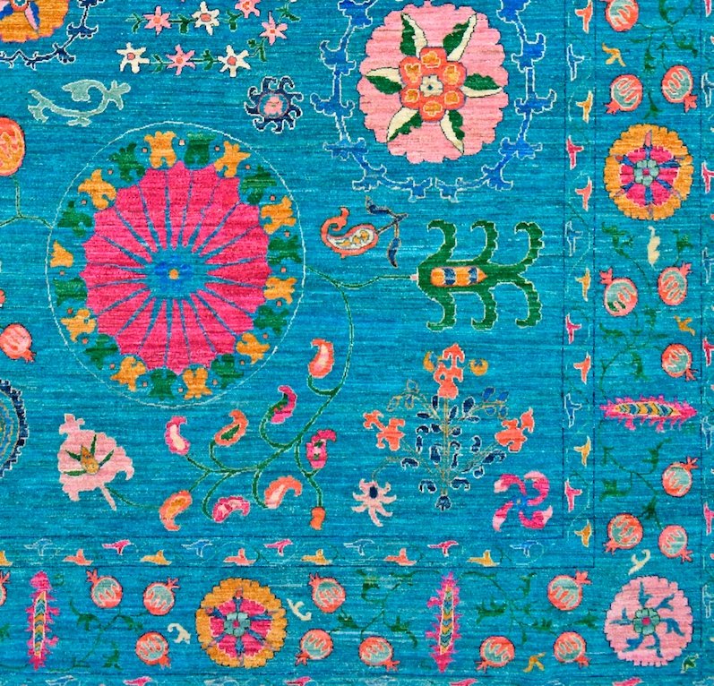 A vibrant blue Afghan Chobi rug featuring intricate floral and geometric patterns in wool.