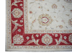 A handmade Afghan Chobi rug featuring a cream field with floral motifs and a red border.