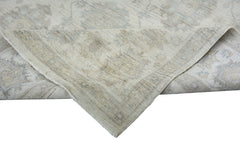 A handmade Afghan Chobi rug with a folded corner showing its light-toned wool texture.