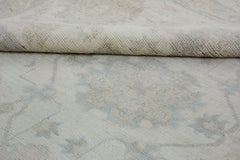 A close-up of a handmade Afghan Chobi rug featuring a subtle, light-toned floral pattern.