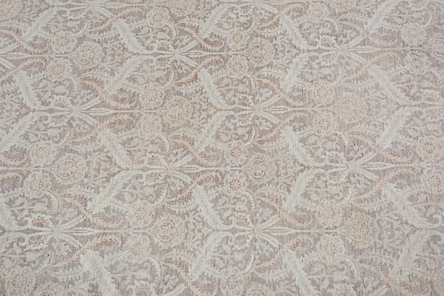 An Afghan Chobi rug featuring a traditional floral pattern in soft beige and brown tones.
