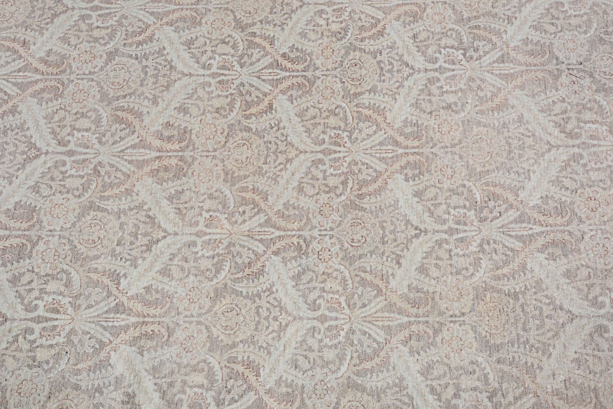 An Afghan Chobi rug featuring a traditional floral pattern in soft beige and brown tones.