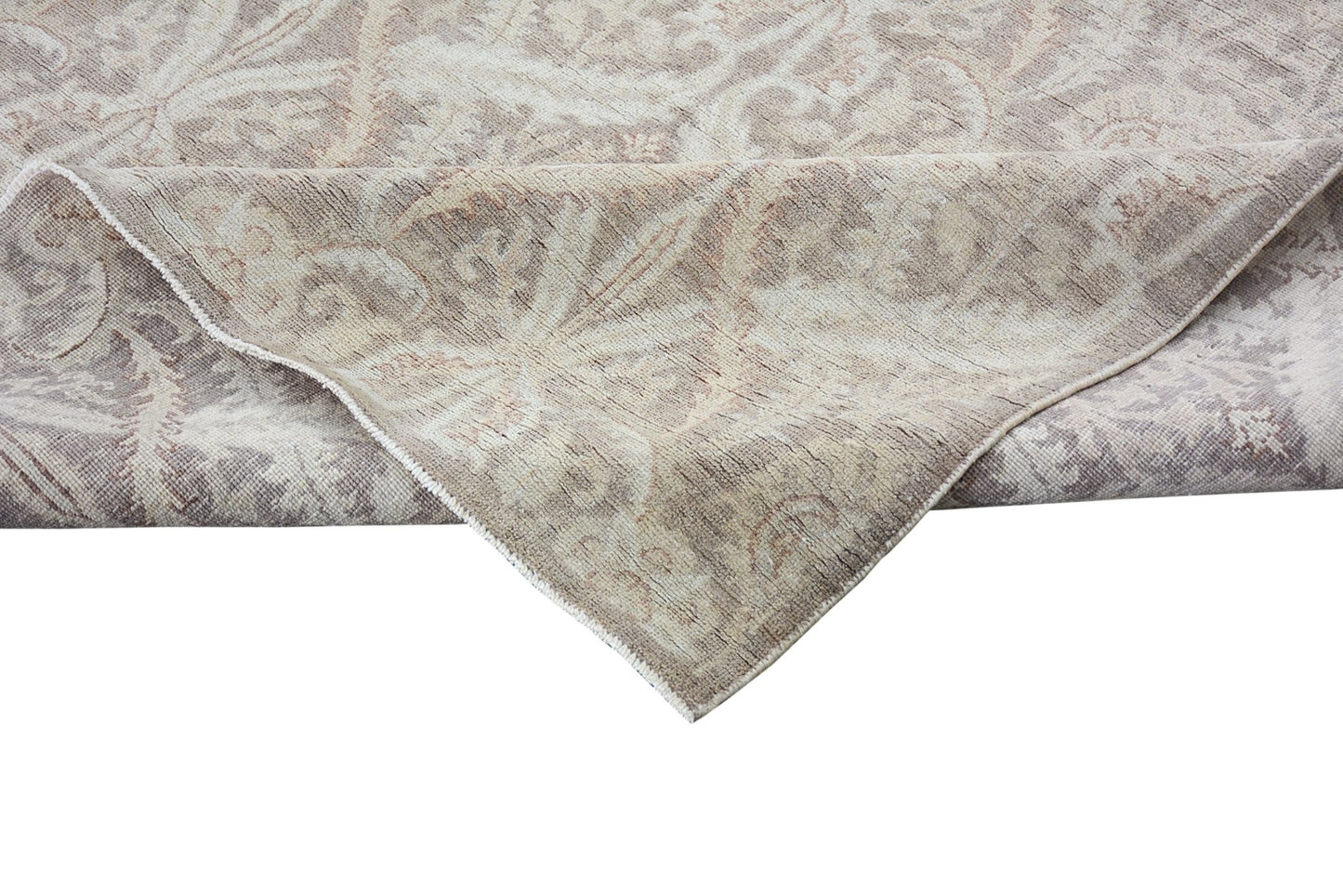 A handmade Afghan Chobi rug featuring a traditional floral pattern in neutral wood tones.