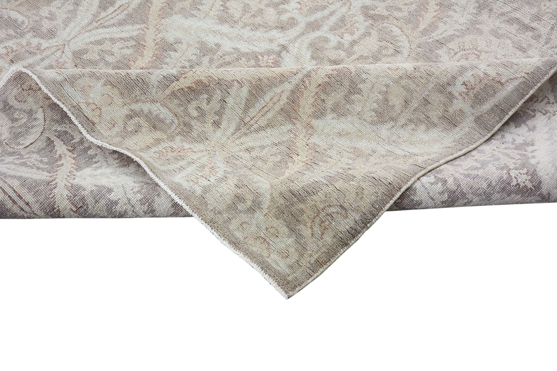 A handmade Afghan Chobi rug featuring a traditional floral pattern in neutral wood tones.