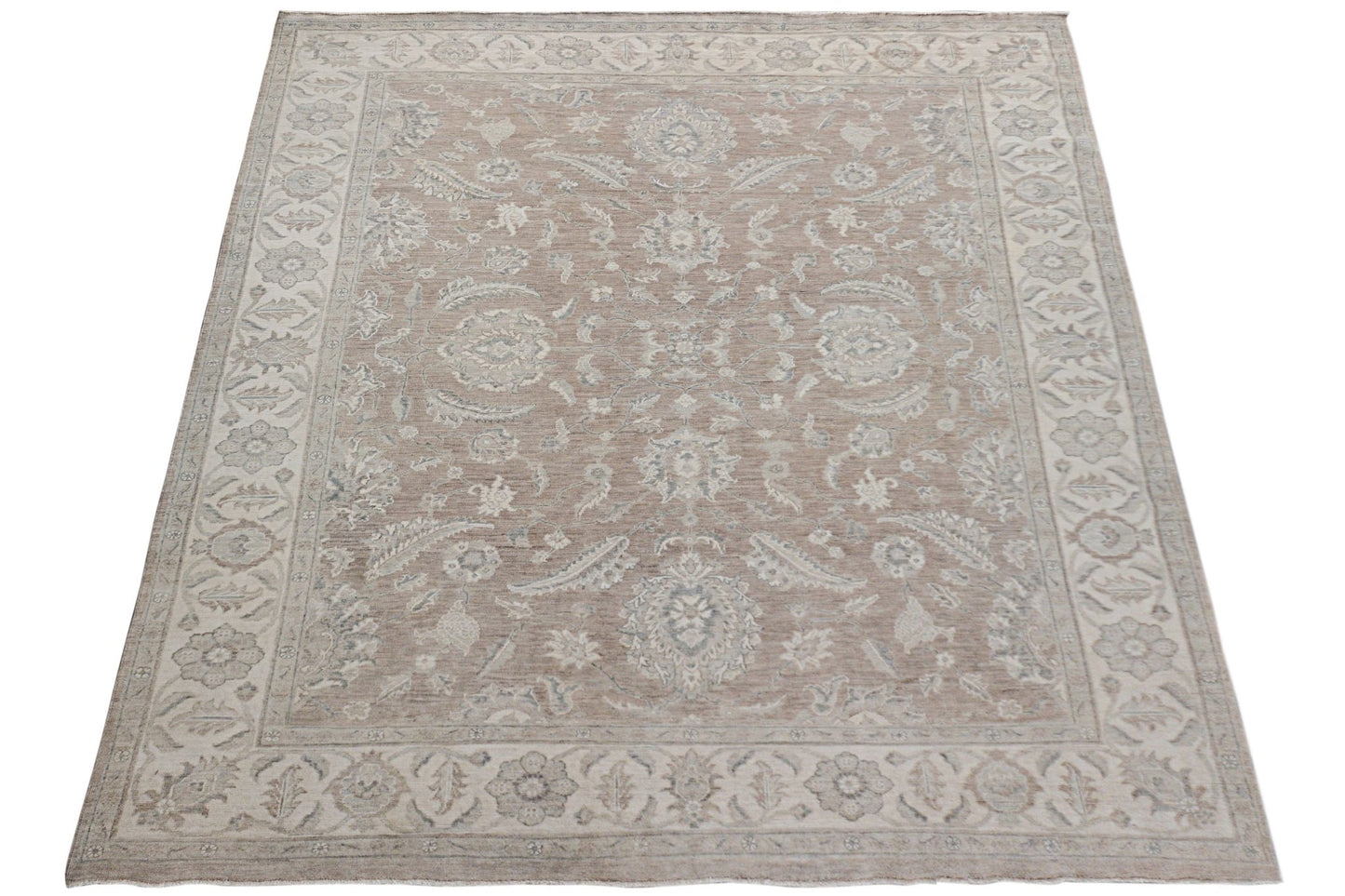 An Afghan Chobi rug featuring a traditional floral pattern in soft beige and grey tones.