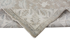 A handmade Afghan Chobi rug with a traditional floral pattern in neutral wood tones.