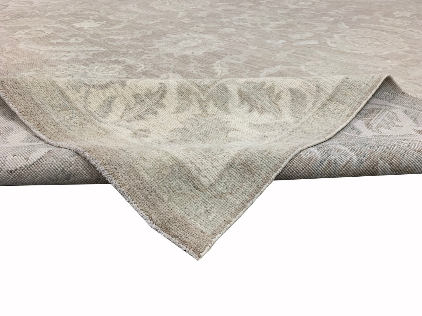 A handmade Afghan Chobi rug featuring a traditional floral pattern in neutral beige tones.