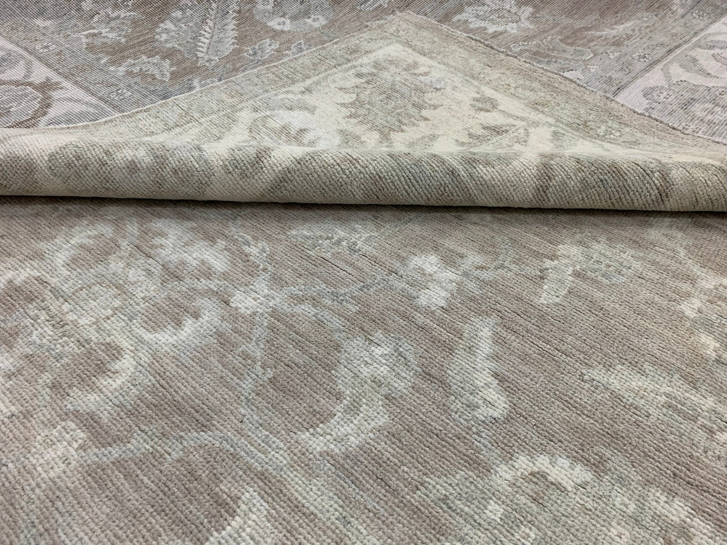A handmade Afghan Chobi rug featuring a traditional floral pattern in neutral beige tones.