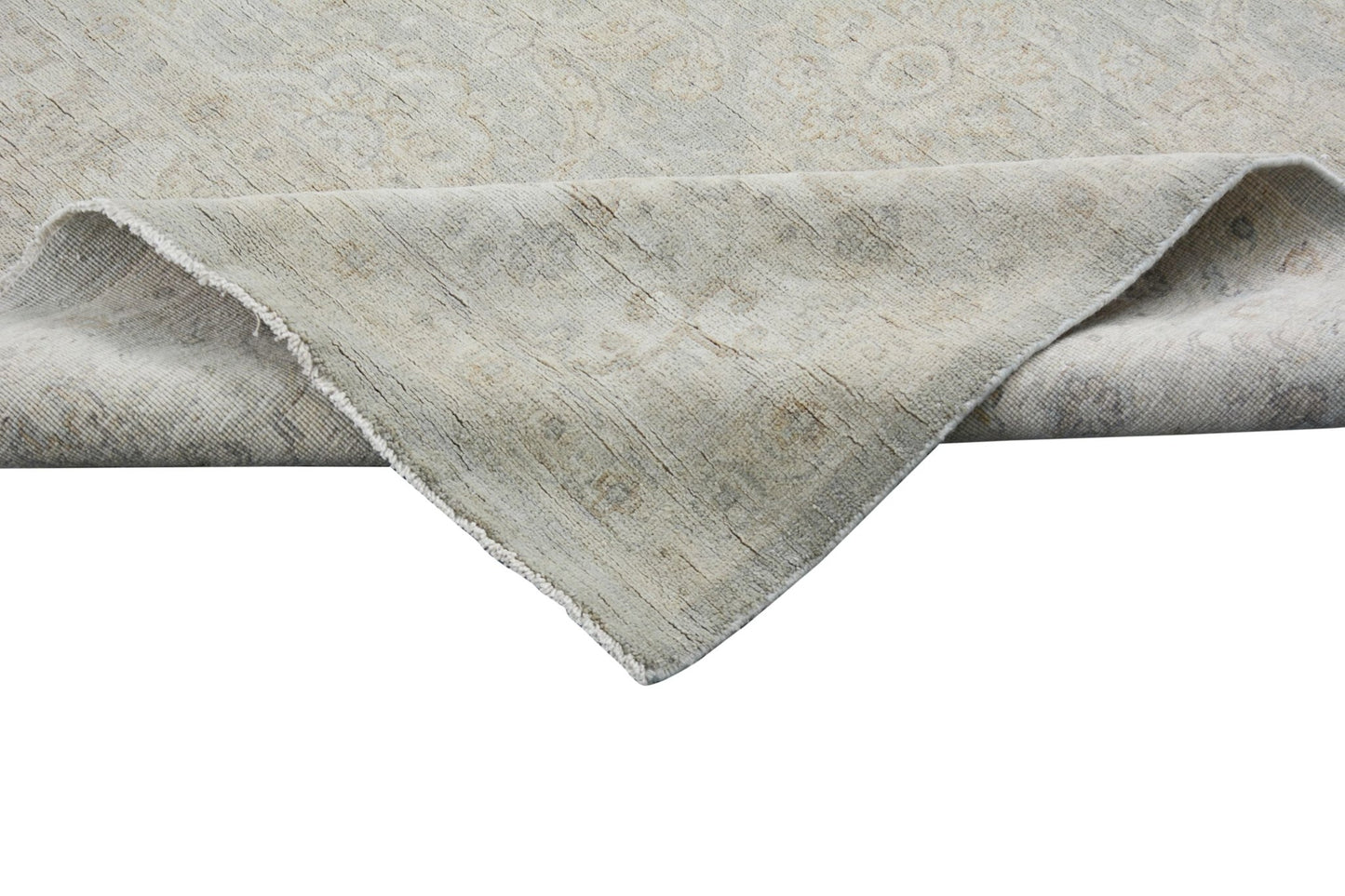 A corner of a handmade Afghan Chobi rug with a neutral, wood-toned traditional pattern.