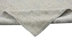 A corner of a handmade Afghan Chobi rug with a neutral, wood-toned traditional pattern.
