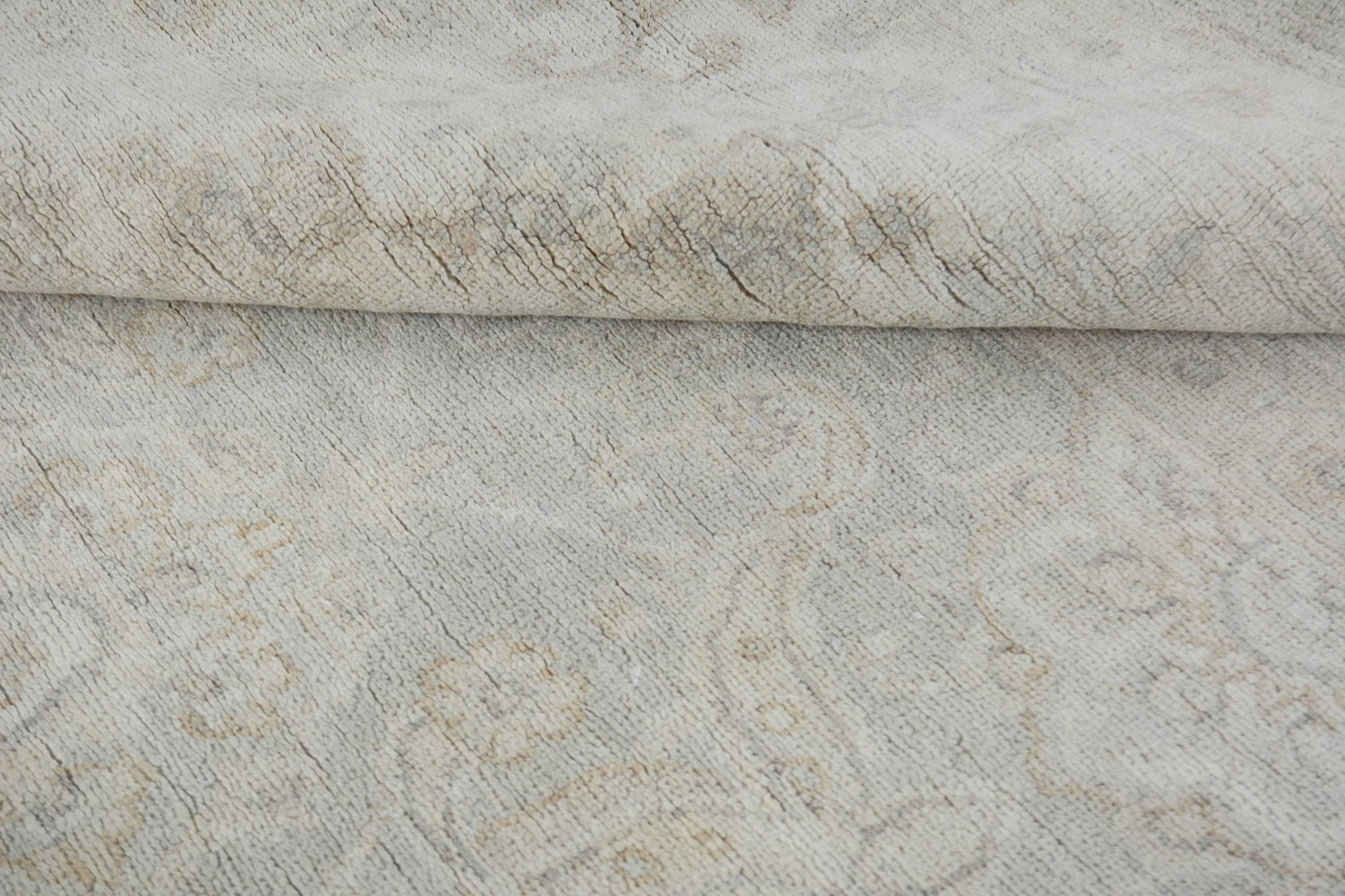 A handmade Afghan Chobi rug featuring a subtle, light-toned traditional pattern in wool.